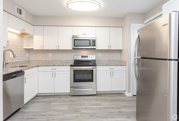 A kitchen with white cabinets and stainless steel appliances at The Preserve at Pine Valley Apartments, Wilmington, NC